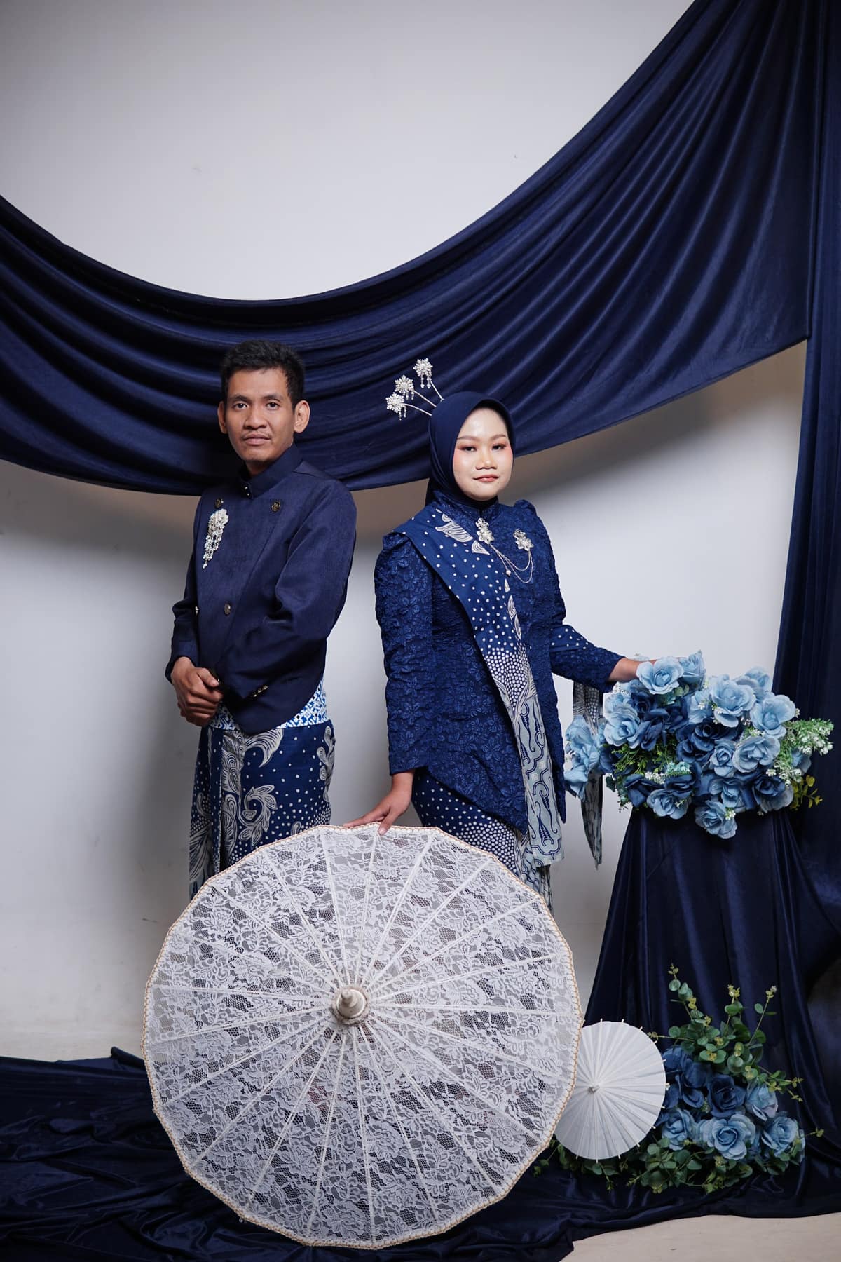 Ula dan Fadli berdiri bersama dengan payung renda