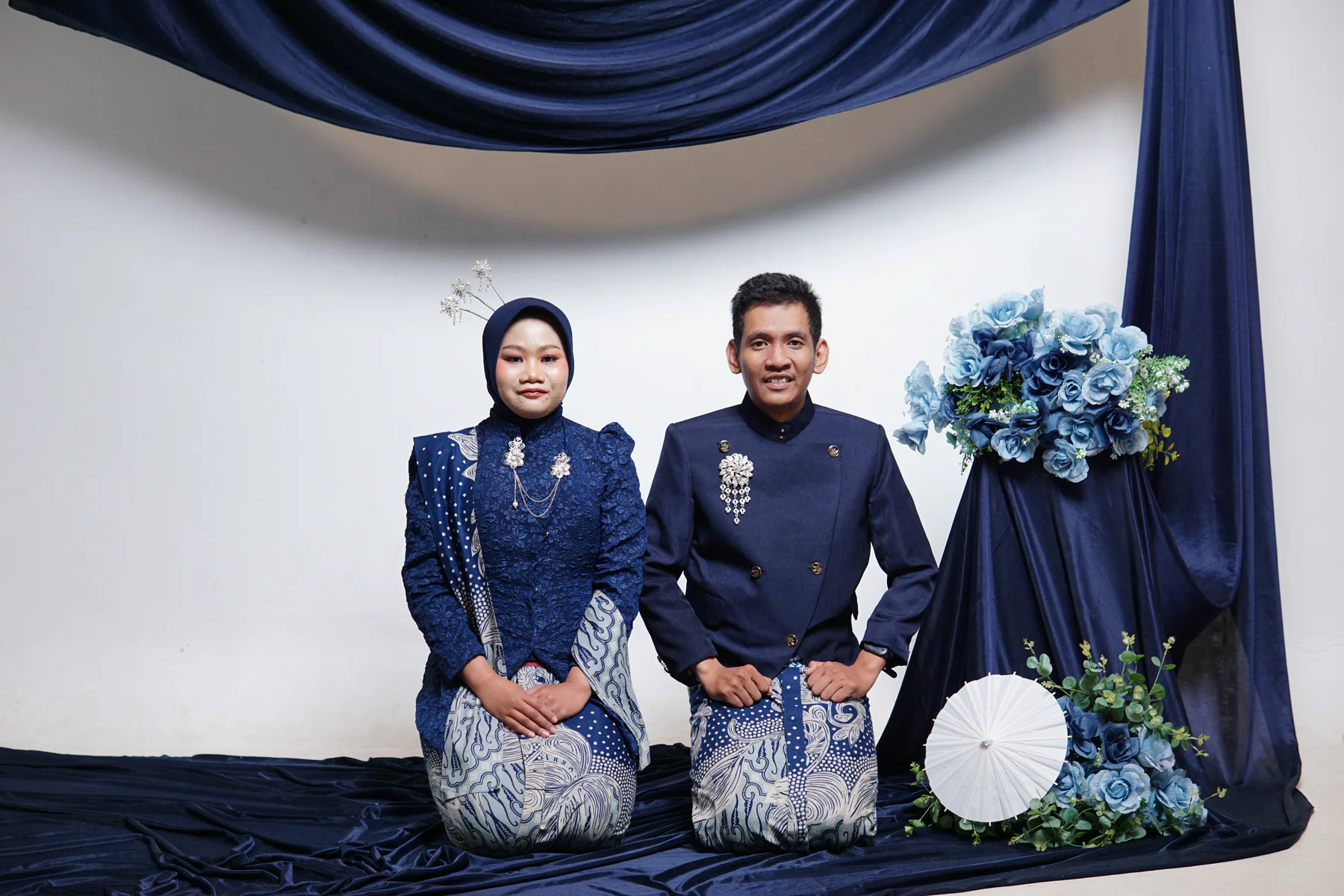 Dewi dan Fadli duduk berdampingan dalam busana biru